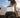 Carrying an Explorer Bear portable fridge-freezer by its handle beside a pickup truck